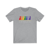 Friends are the Family we Choose Unisex Jersey Tee  - Image Description - Heather grey t-shirt with Friends written in the middle of 7 sitting dogs in rainbow colors, with are the family we choose in white under the 7 dogs.