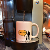 What I Like Best About People 11oz Mug - This image has a white mug with a silhouette of a dog sitting next to a guy standing with a bright yellow speech bubble coming from the man. The man says, "Their Dogs!" The mug is sitting on a one cup coffee machine with coffee being dispensed into the mug.