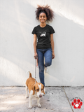 Sniff Happens Jersey Tee - Image Description - Teenager leaning against a wall walking a tan and white hound. The teen is wearing a black t-shirt with white text "Sniff Happens" above a white silhouette of a dog sniffing.